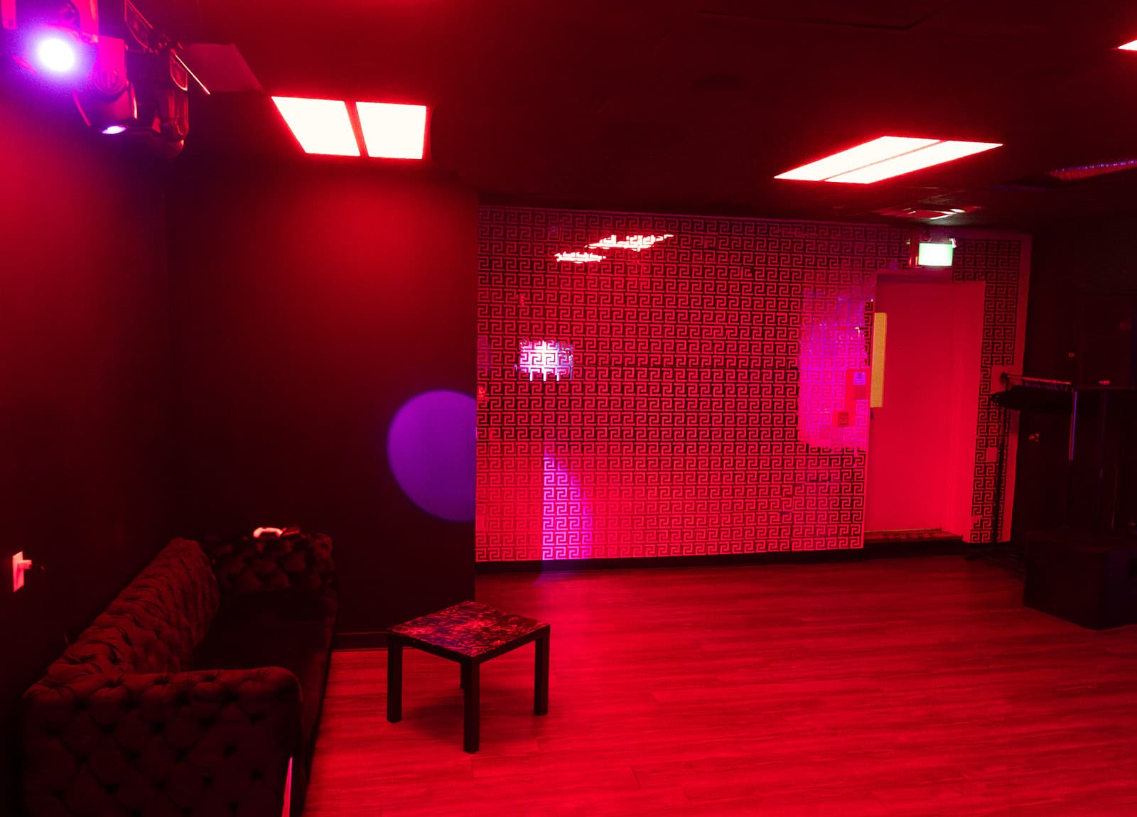 Red Versace-pattern wall and velvet couches